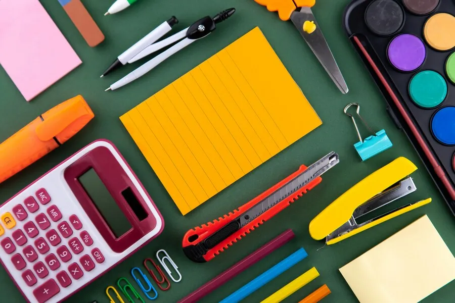 Material escolar con calculadora, pinturas, tijeras y material de papelería