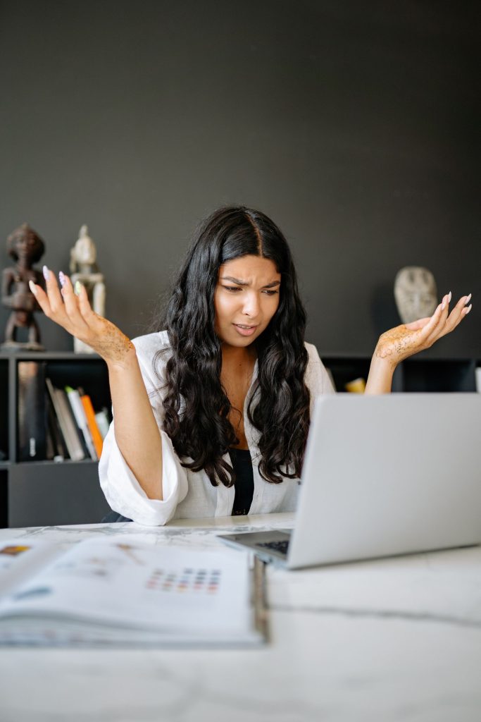 Mujer mirando con desconfianza la pantalla de su portátil