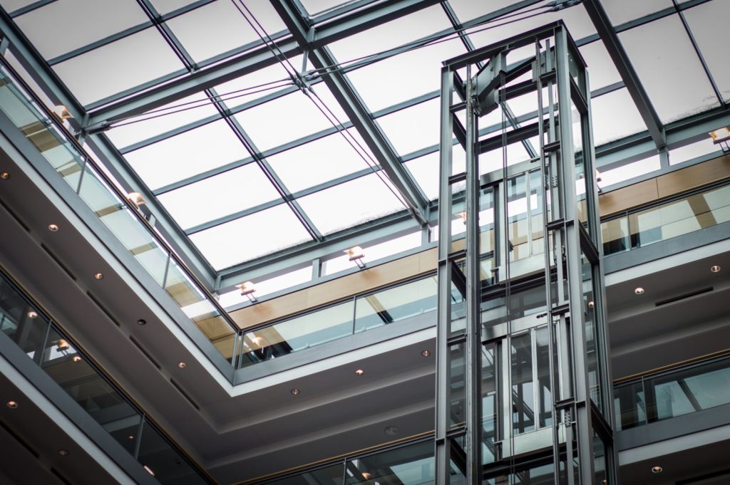 Ascensor moderno instalado en el hueco de la escalera de un edificio, estructura de acero y cristal