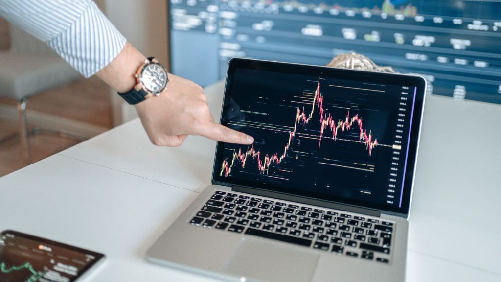 Persona señalando un gráfico de datos en la pantalla de un portátil