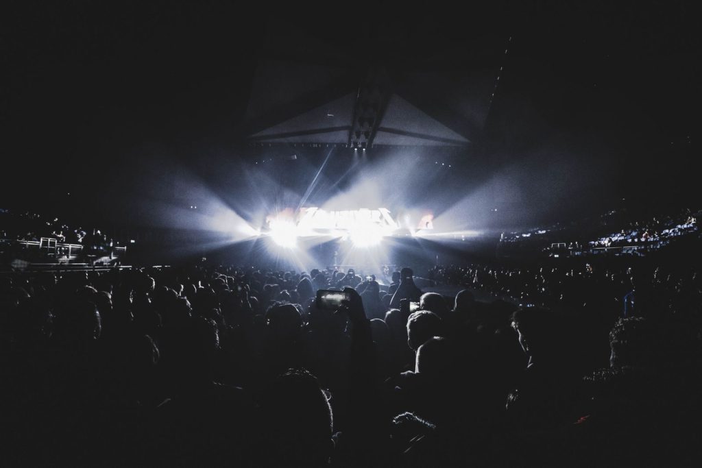 Público en un estadio durante un concierto nocturno con luces