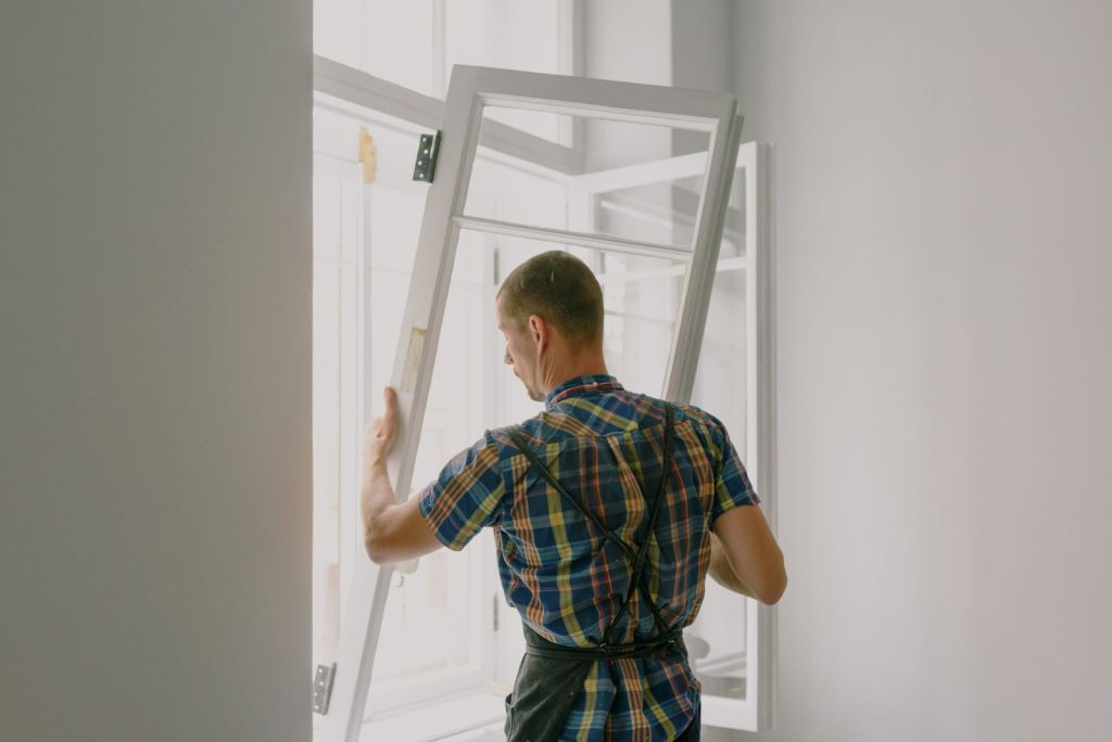 Operario instalando una ventana durante una reforma de vivienda