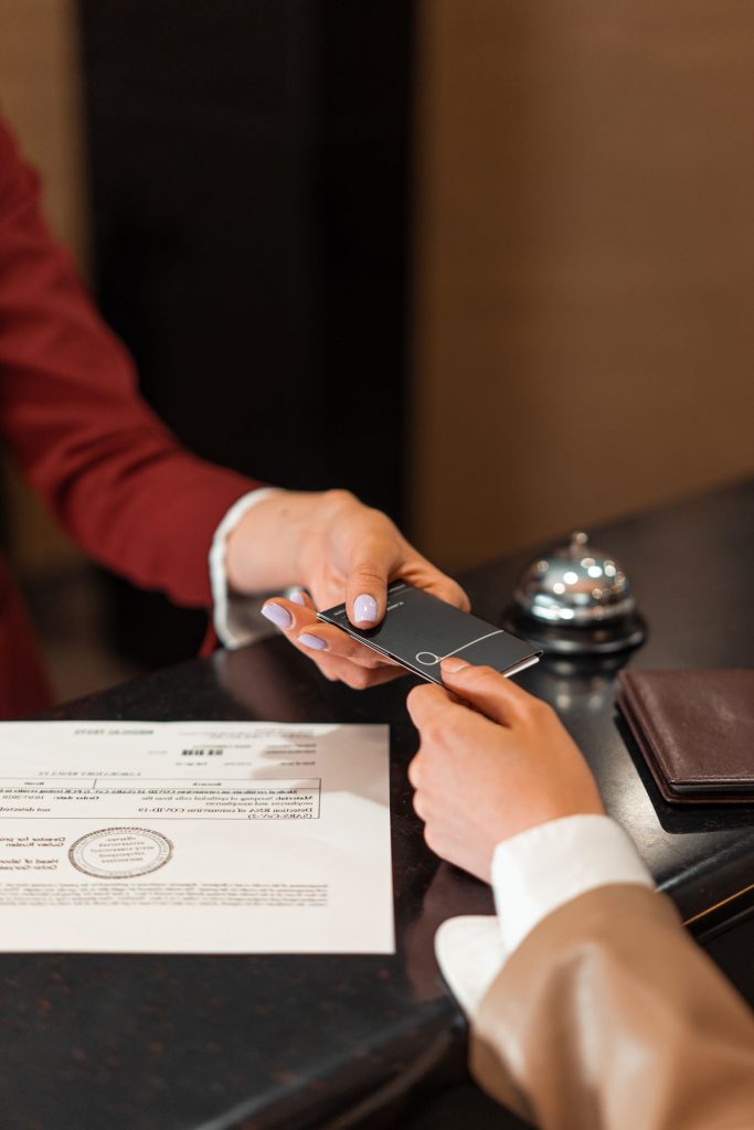Recepcionista de hotel entregando una tarjeta llave a un huésped