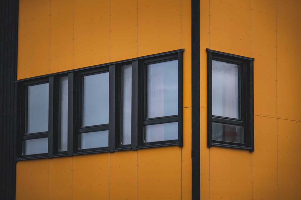 Fachada de un edificio en tono amarillo cálido y envejecido