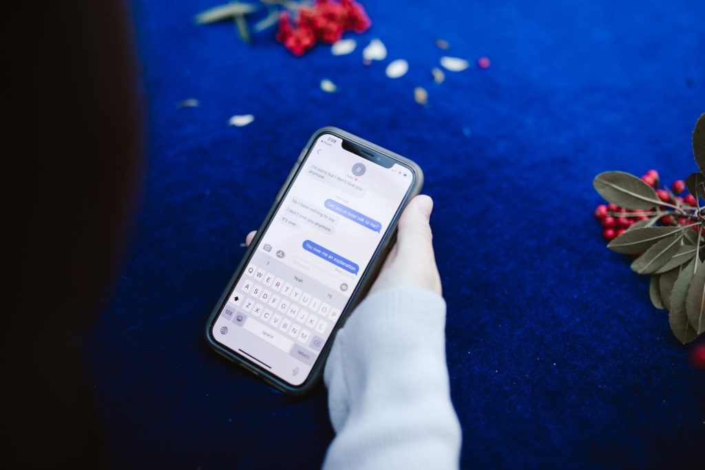 Persona mostrando mensajes de texto en la pantalla de un móvil