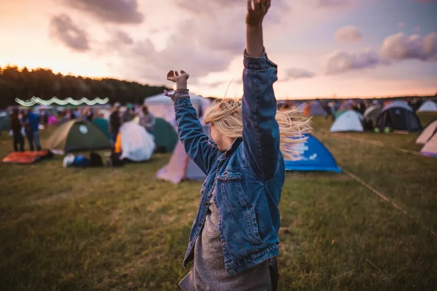 Festival de música al aire libre con público y zona de acampada