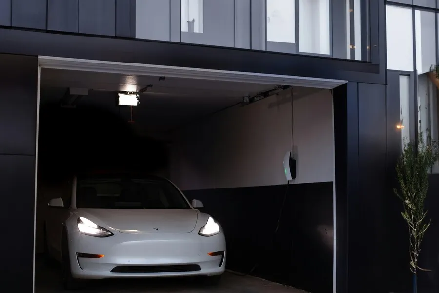 Coche eléctrico conectado a un cargador doméstico en un garaje