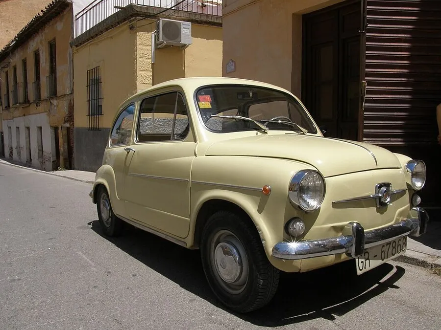 SEAT 600 de color amarillo estacionado en una calle