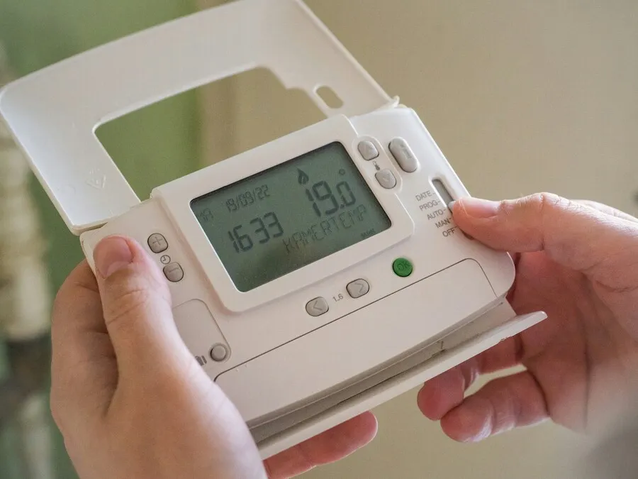 Persona ajustando un programador para controlar el consumo eléctrico