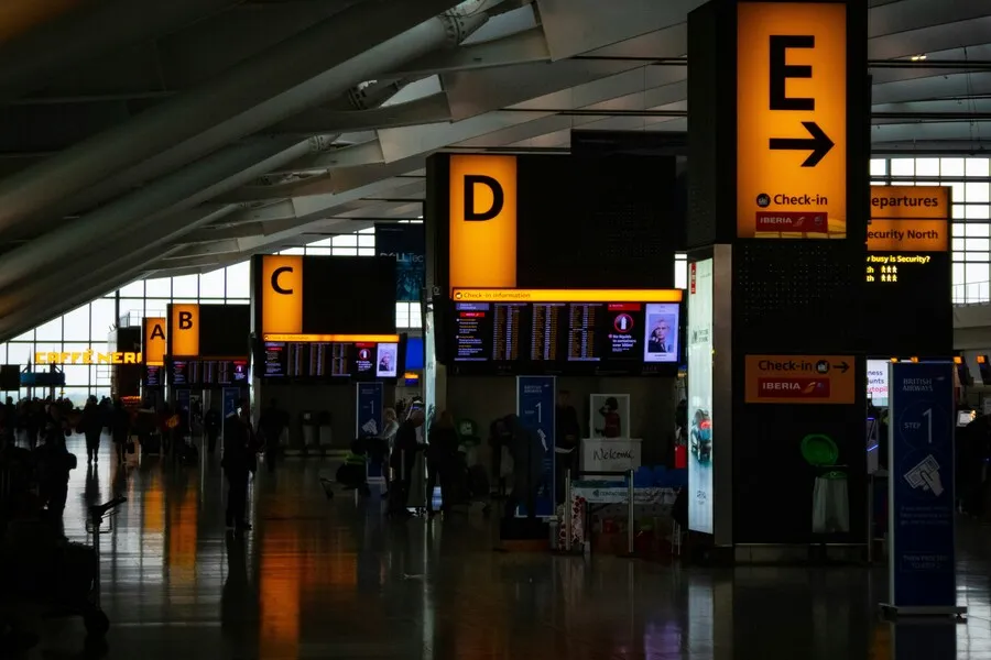 Terminal de aeropuerto con mostradores de facturación y paneles de vuelos